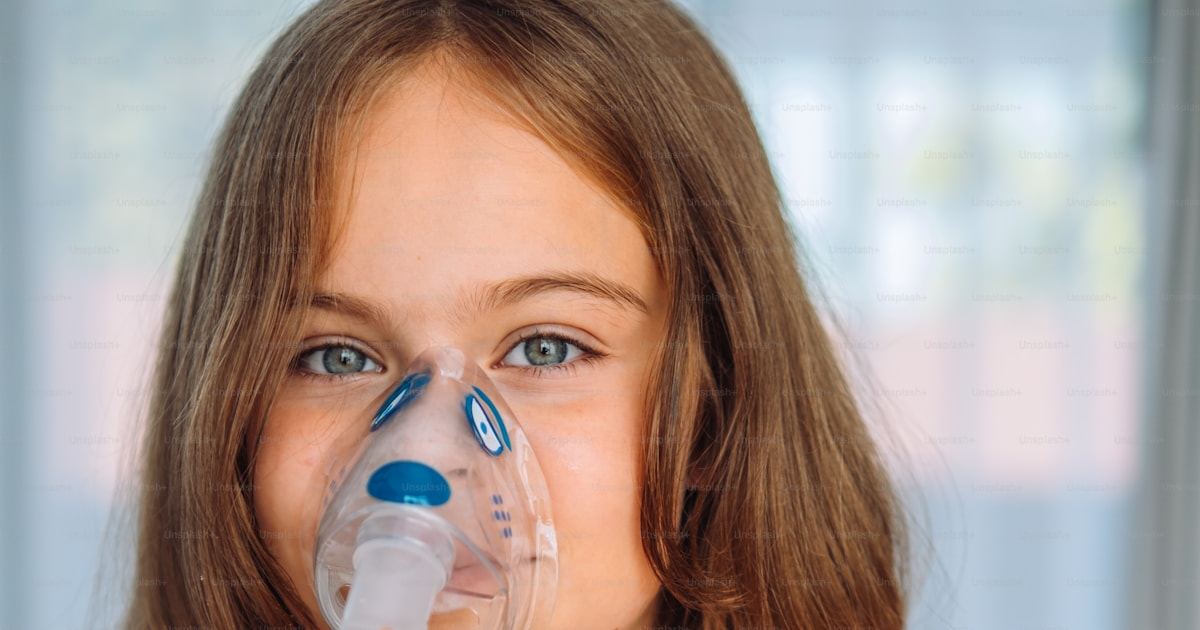 Young girl using a nebuliser mask for asthma treatment