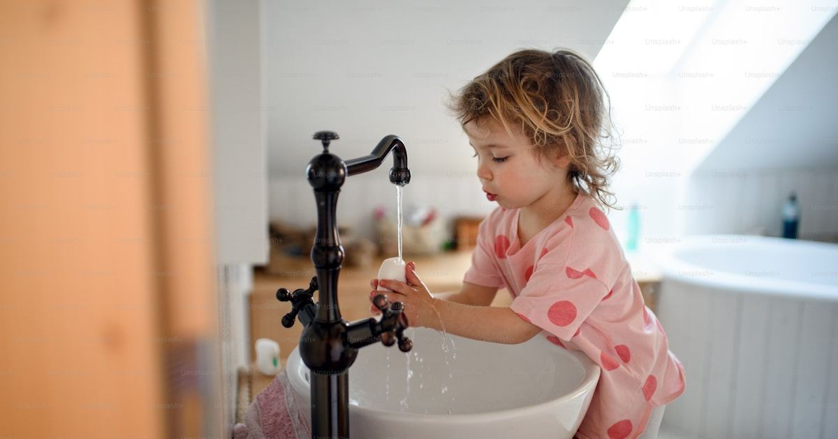 Young child washing hands at a basin to prevent worm infection