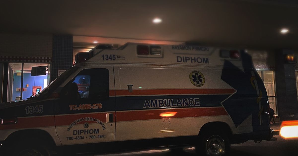 Ambulance outside a 24 hour emergency and trauma care unit at night