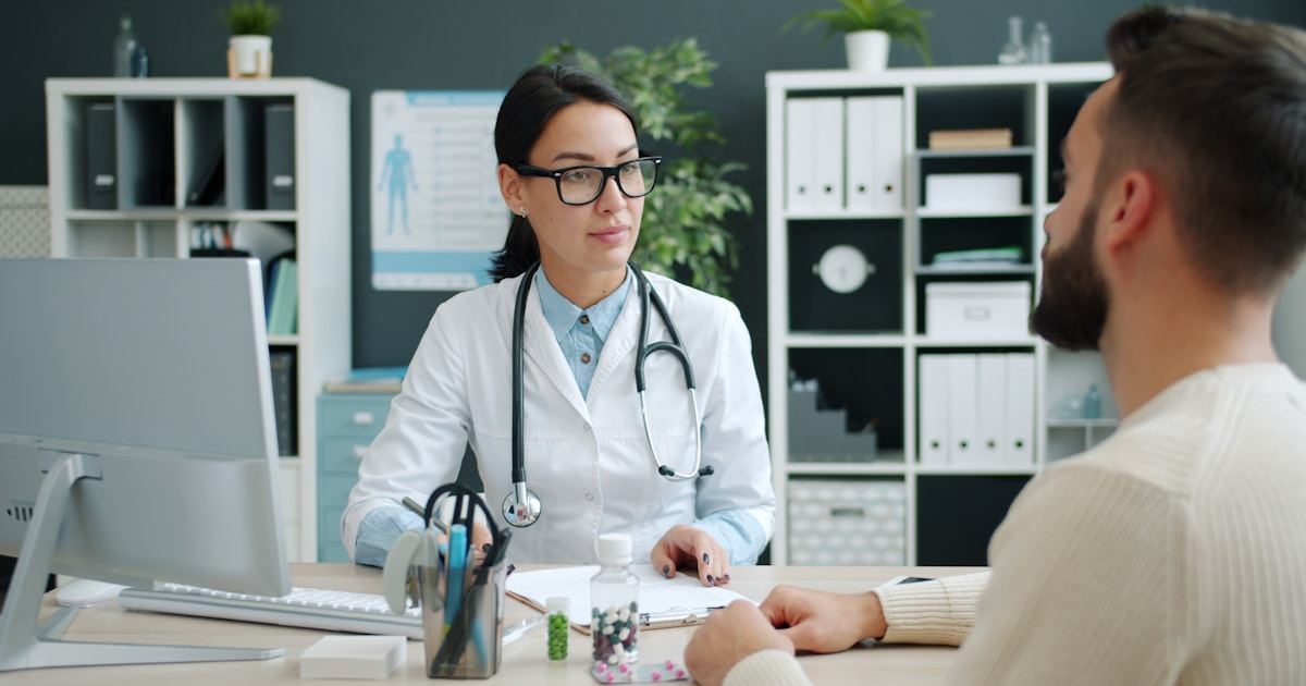 Doctor consulting a male patient about semen analysis results in a clinic