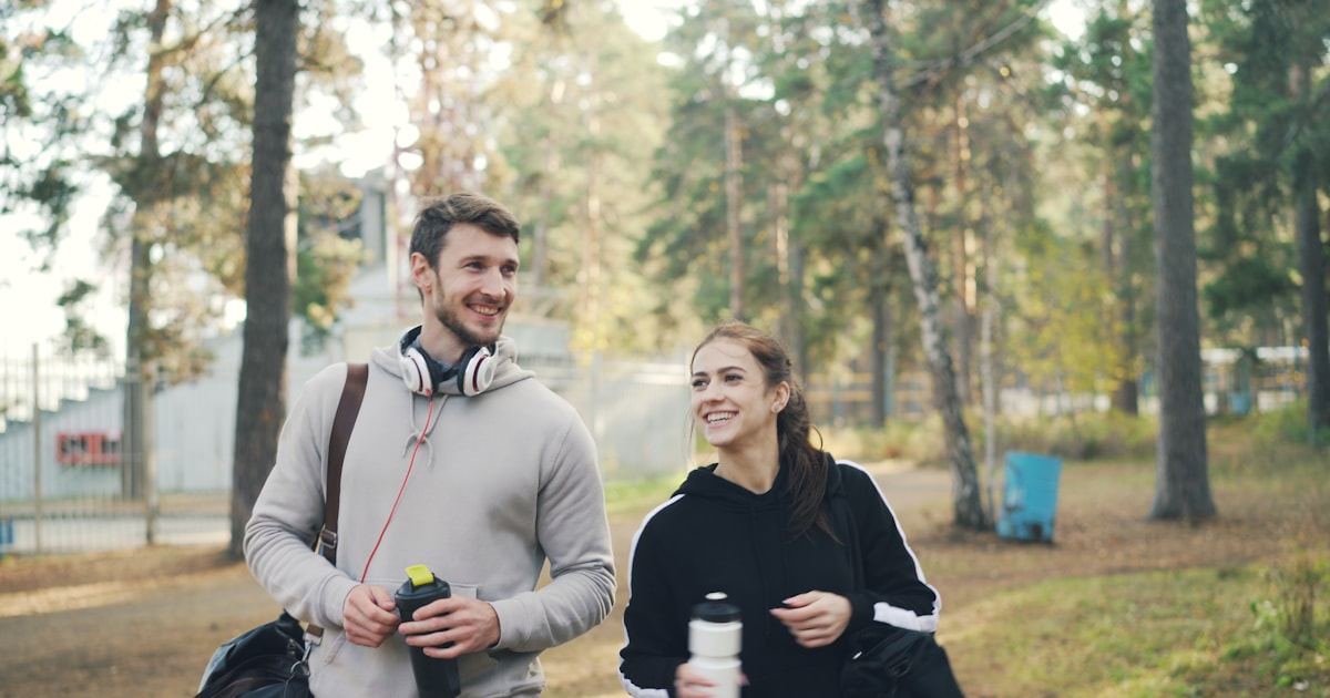Couple walking outdoors with water bottles while preparing for an IVF cycle